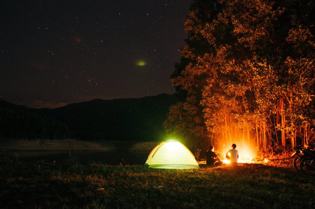 pexels-photo-10552759 A tranquil camping scene at night with a tent and campfire under a starry sky in Chư Sê, Vietnam.